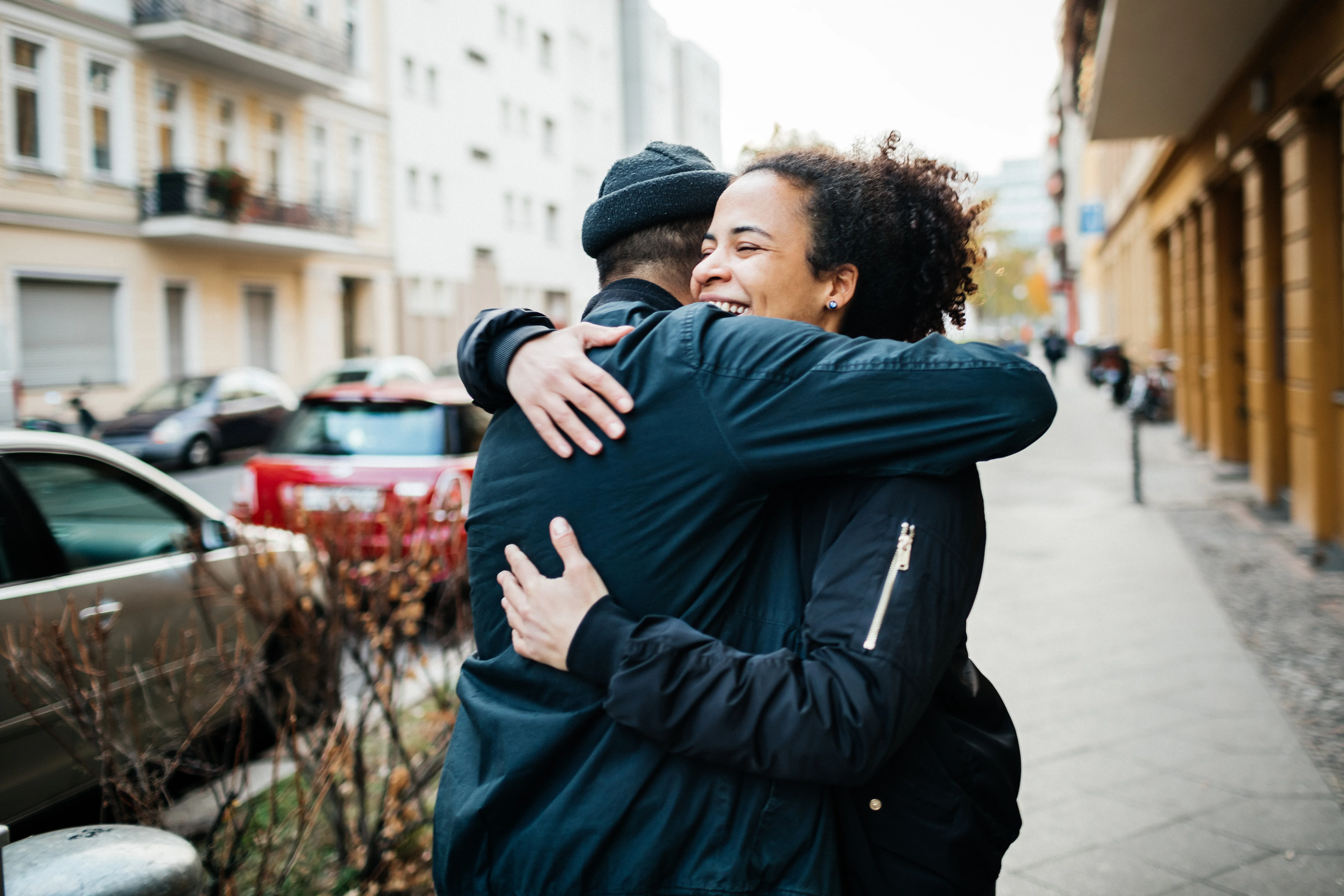 a man and woman kissing on a sidewalk