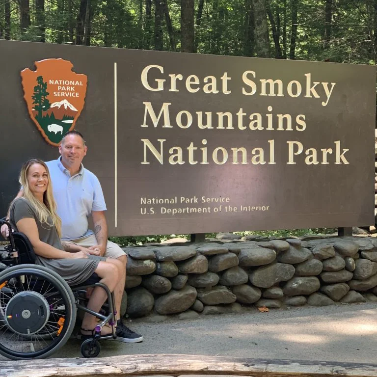 um homem e uma mulher em uma cadeira de rodas por um sinal