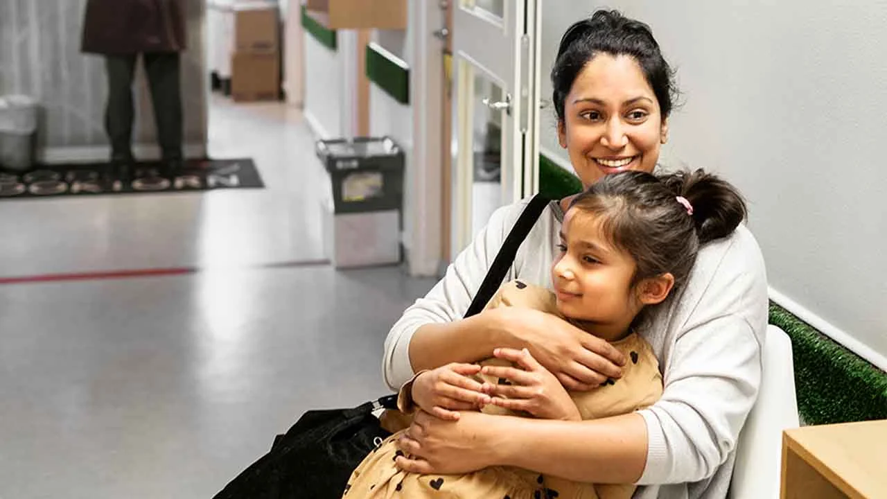 Une femme porte un enfant dans ses bras