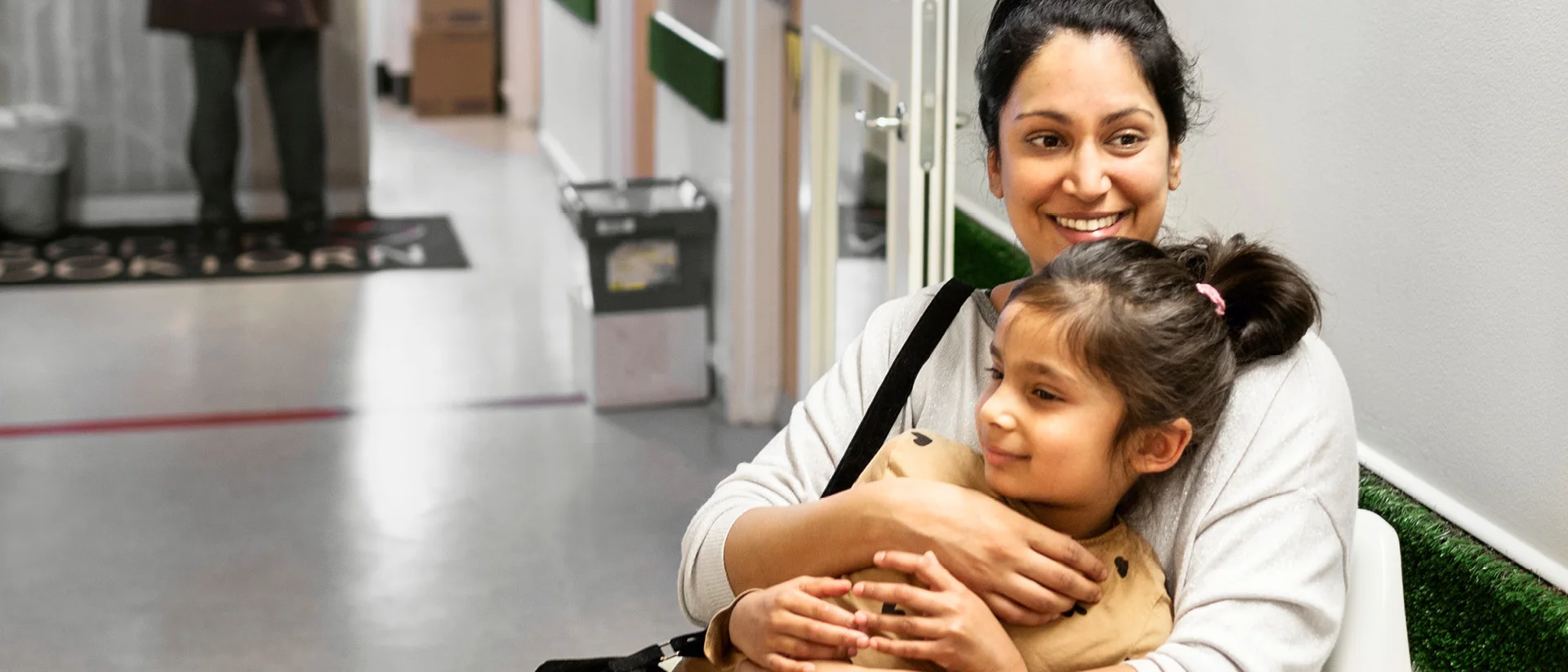 Nainen pitää lasta sylissään