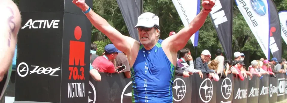 muž v modrej košeli a bielom klobúku so zdvihnutými rukami