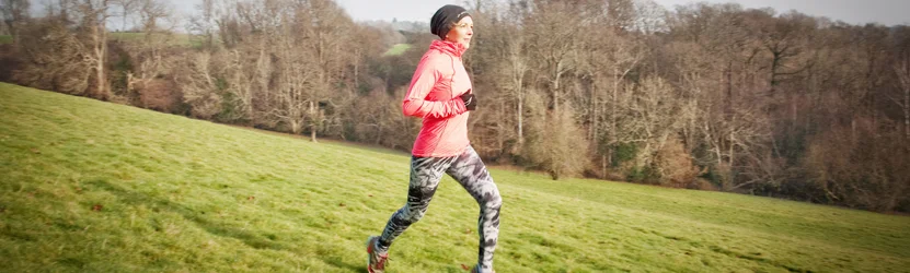 a man running on a grassy hill