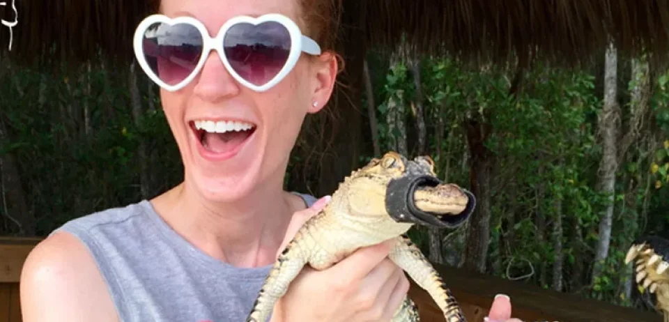 uma mulher segurando um lagarto